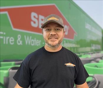 SERVPRO team member in front of new background image