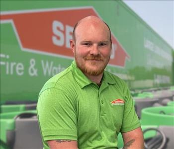 SERVPRO team member in front of new background image