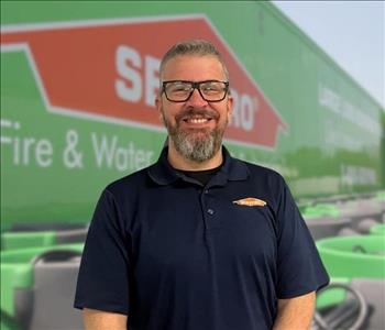 SERVPRO team member in front of new background image