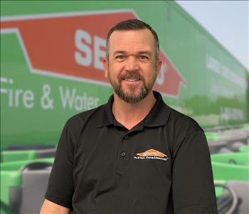 SERVPRO team member in front of new background image