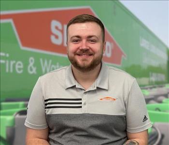 SERVPRO team member in front of new background image