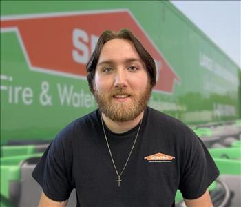 SERVPRO team member in front of new background image