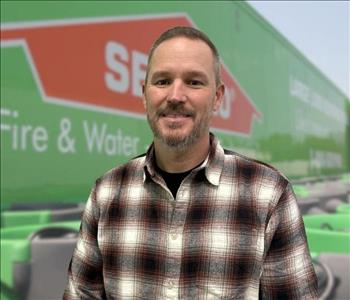 SERVPRO team member in front of new background image